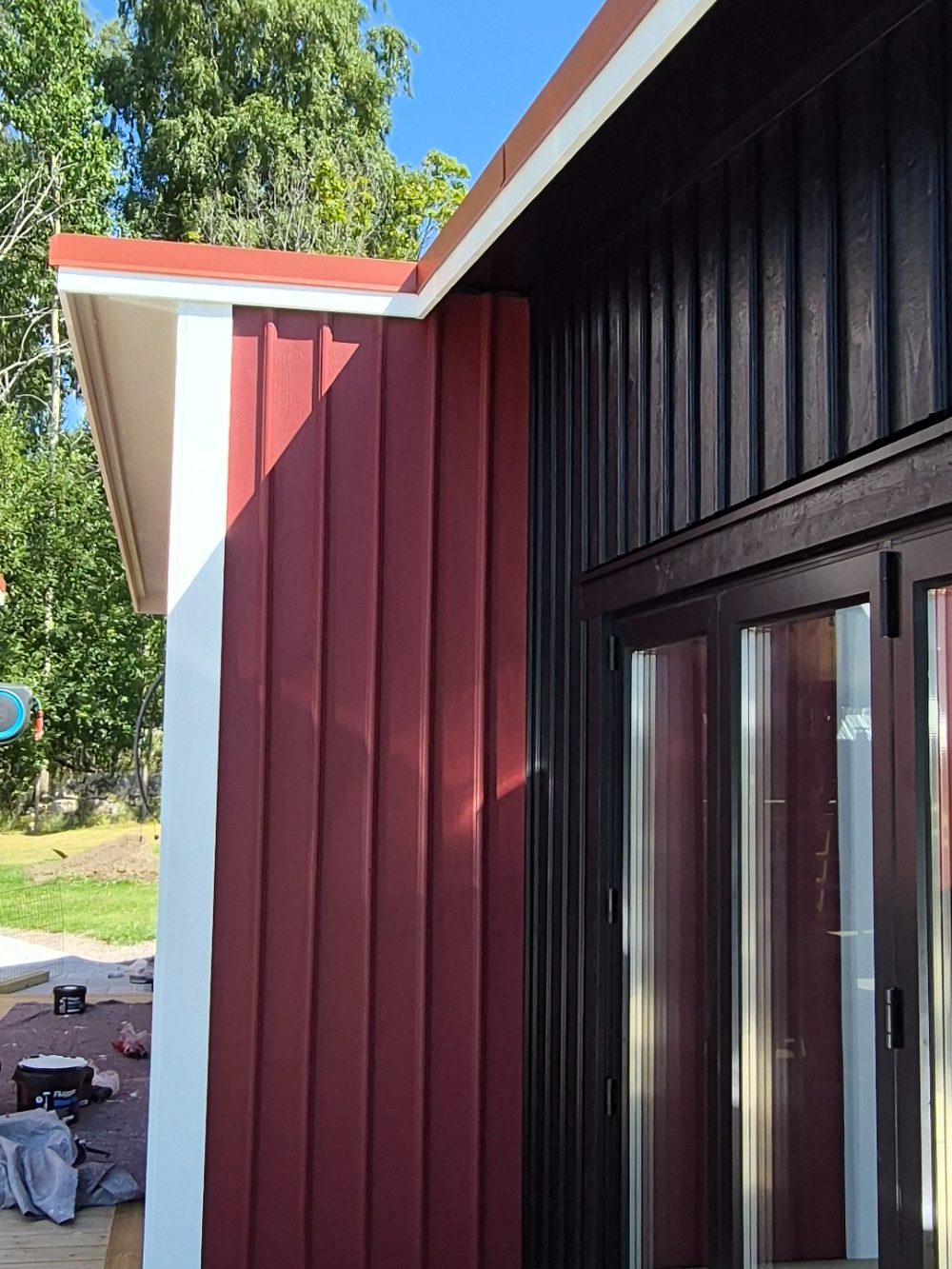 Svartmålad och rödmålad panel som möts vid vit knutbräda